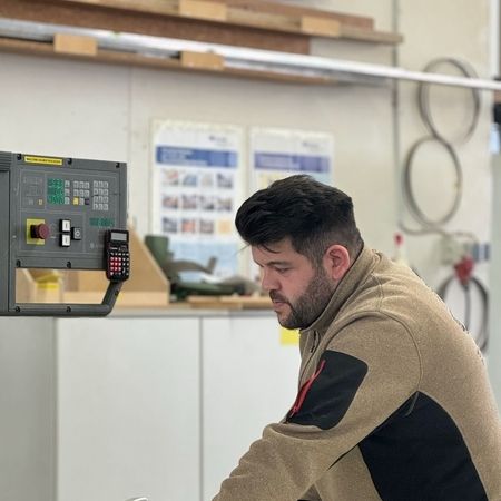 Referenzen - Ein Mitarbeiter bearbeitet ein Holzstück